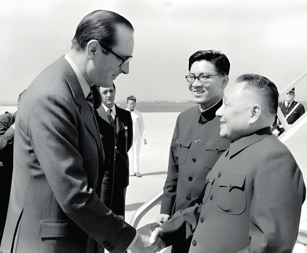 Fransa Başbakanı Jacques Chirac (solda), 12 Mayıs 1975'te Başbakan Yardımcısı Deng Xiaoping'i (sağda) havaalanında karşılıyor (Fotoğraf: China Daily, 2014).
